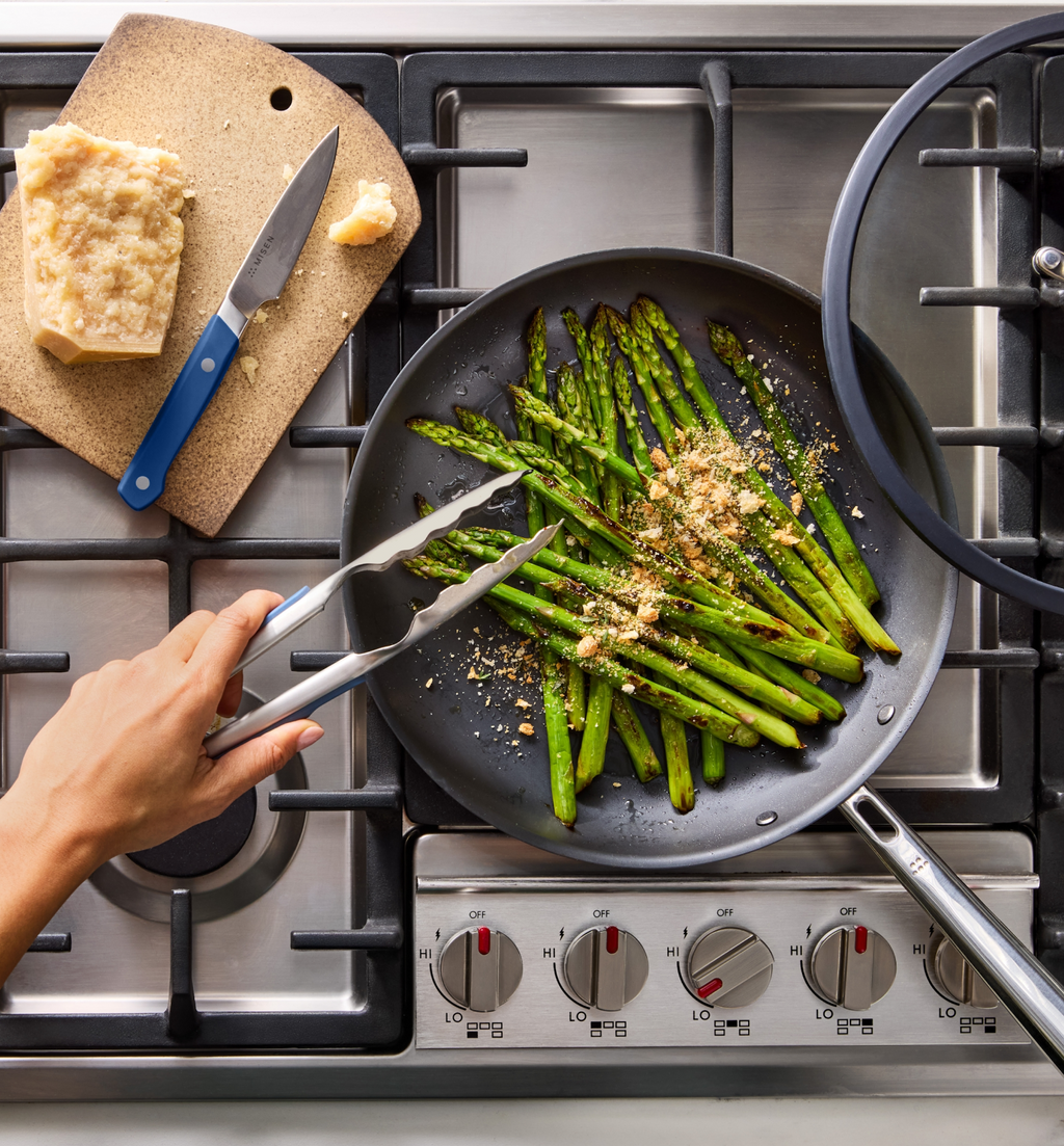 Sautéed asparagus with Parmesan in a nonstick skillet on a gas stove